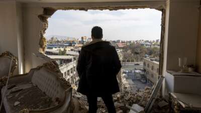 A man stands in a damaged residence at the site of buildings that were destroyed in an airstrike in the Khani Abad neighbourhood of Tehran, Iran, on March 14, 2026.