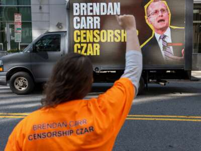 Activists gather as a mobile billboard truck accusing FCC Chair Brendan Carr of censorship is seen outside the FCC Headquarters in Washington, D.C., on March 26, 2026.