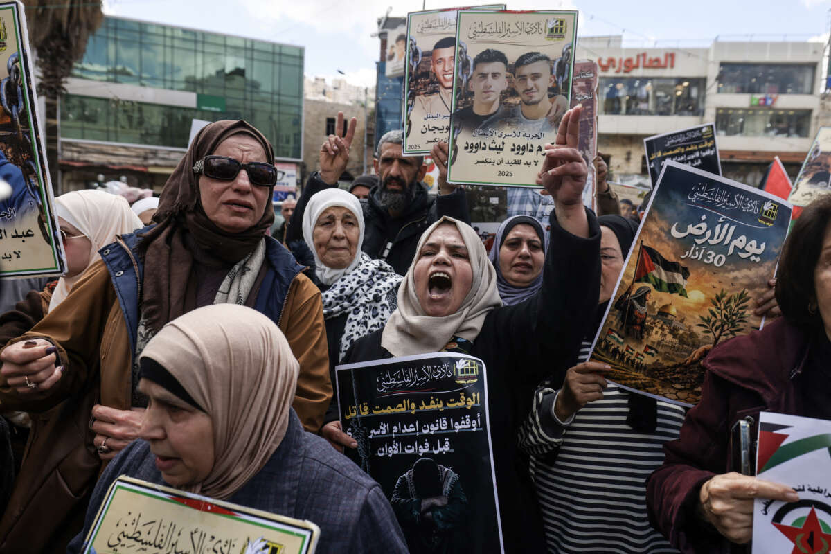 Relatives of Palestinian prisoners hold portraits and shout slogans during a rally in the Israeli-occupied West Bank city of Nablus, on March 31, 2026, against a bill approved by Israel's parliament that would allow the execution of Palestinians convicted on terror charges.