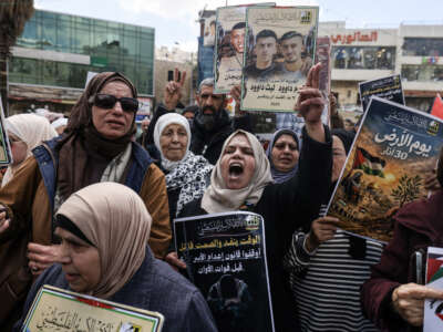 Relatives of Palestinian prisoners hold portraits and shout slogans during a rally in the Israeli-occupied West Bank city of Nablus, on March 31, 2026, against a bill approved by Israel's parliament that would allow the execution of Palestinians convicted on terror charges.