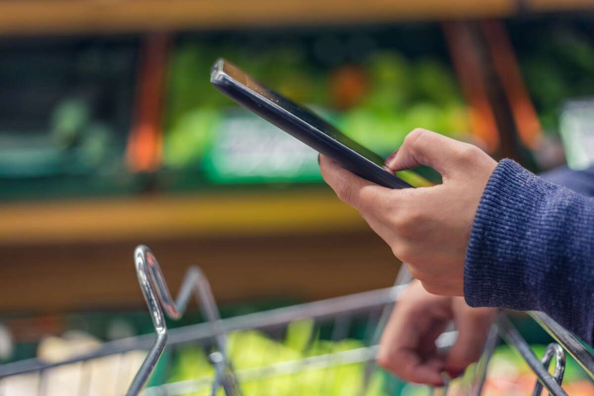 Hand holding a phone in grocery store