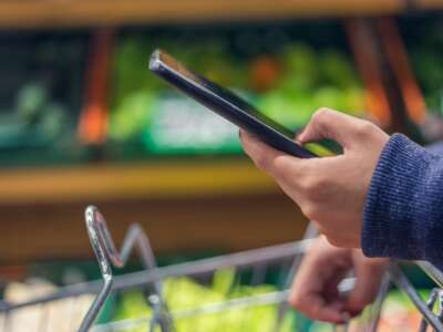 Hand holding a phone in grocery store