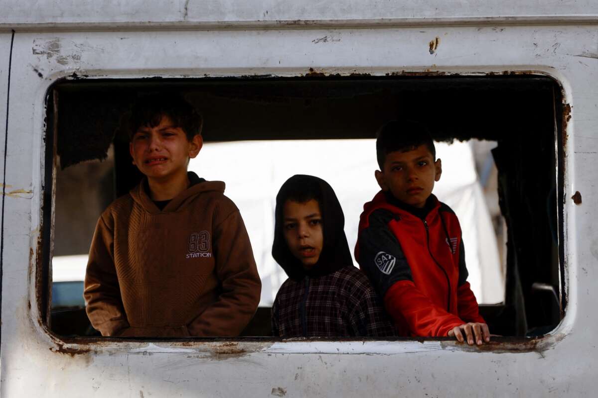 Children react as the bodies of Palestinian victims reportedly killed in Israeli strikes earlier in the day are transported at Al-Shifa Hospital in Gaza City on February 4, 2026.