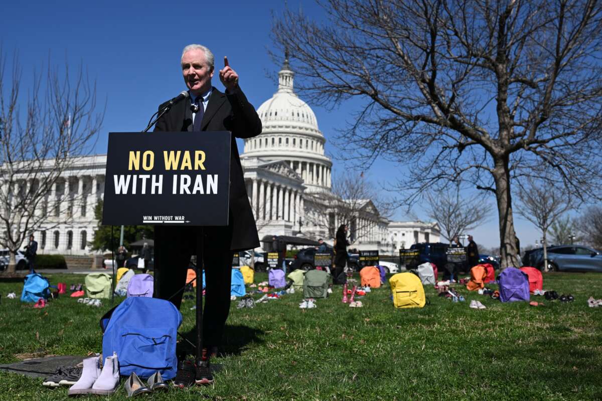 Sen. Chris Van Hollen (D-Maryland) speaks in front of a memorial made up of shoes and backpacks symbolizing those killed in the bombing of the Minab elementary school and other civilians killed in Iran sits outside the United States Capitol on March 18, 2026 in Washington, D.C.