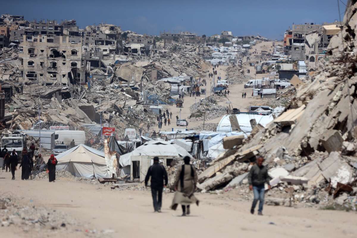 People walk past the rubble of destroyed buildings in the Jabalia camp for Palestinian refugees in the northern Gaza Strip on April 13, 2026.