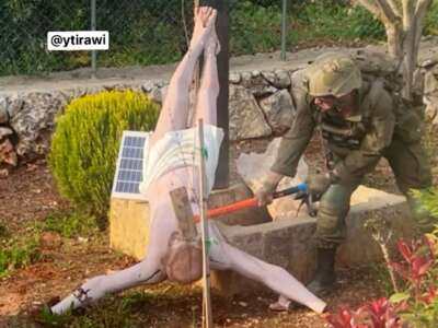 An Israeli soldier smashes the face of a Jesus Christ statue with a sledgehammer in southern Lebanon.
