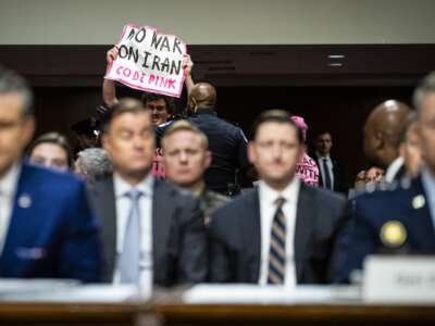 An anti-war demonstrator is removed from the hearing room after interrupting testimony from U.S. Secretary of Defense Pete Hegseth and Chairman of the Joint Chiefs of Staff General Dan Caine, during a Senate Armed Services Committee hearing on April 30, 2026 in the Dirksen Senate Office Building in Washington, D.C.