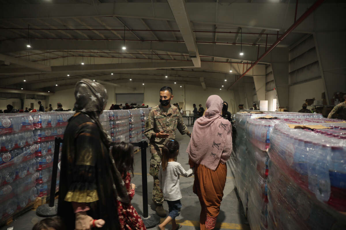 Culinary specialist Sgt. Juan Miranda with the 155th Combat Sustainment Support Battalion directs evacuees into the dining facility at Camp As Sayliyah on August 20, 2021, in Doha, Qatar.