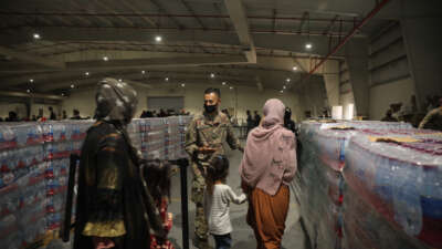 Culinary specialist Sgt. Juan Miranda with the 155th Combat Sustainment Support Battalion directs evacuees into the dining facility at Camp As Sayliyah on August 20, 2021, in Doha, Qatar.