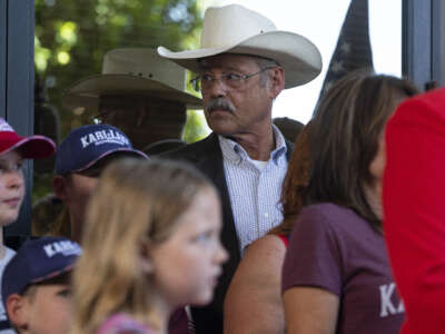 Mark Finchem listens as former Arizona Republican candidate for Governor Kari Lake holds a press conference the day after Maricopa County Superior Court Judge Peter A. Thompson dismissed Lake's final election loss claim on May 23, 2023, in Phoenix, Arizona.