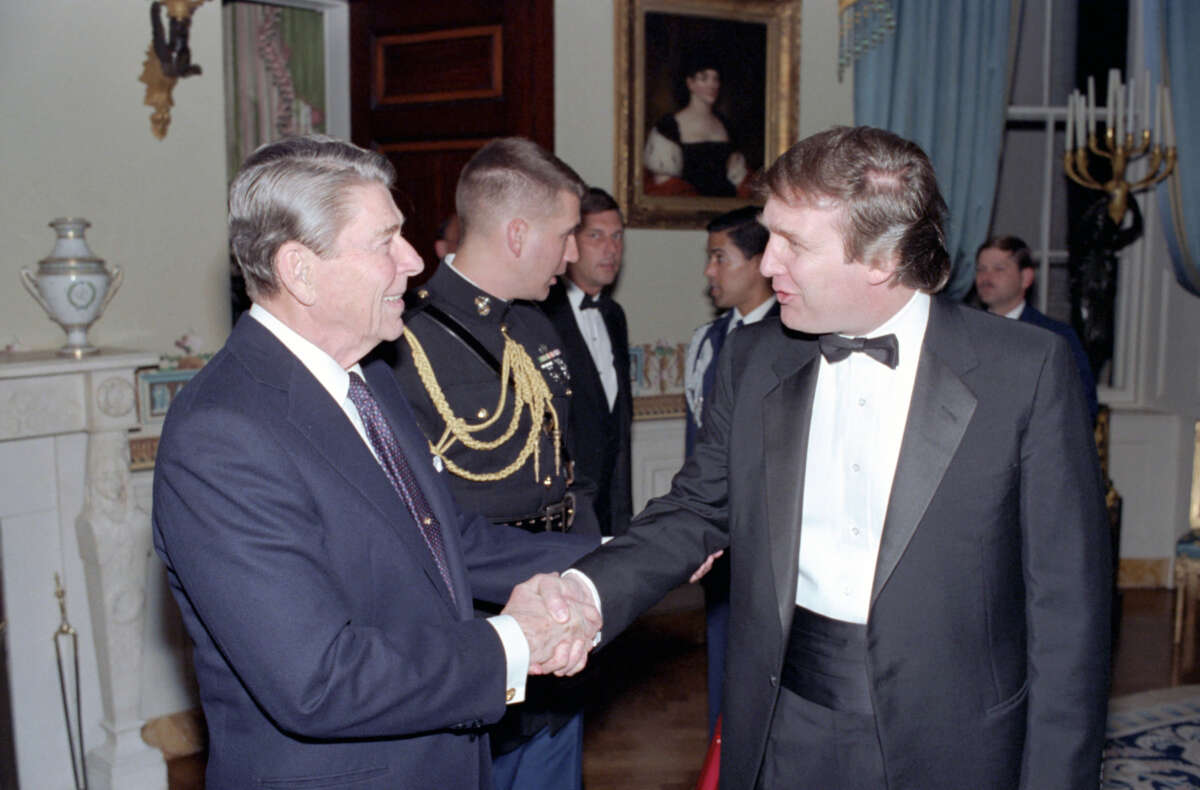Ronald Reagan shakes hands with Donald Trump in a reception line in the White House's Blue Room, in Washington D.C., on November 3, 1987.
