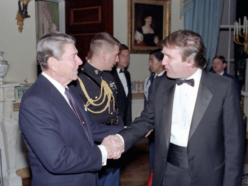 Ronald Reagan shakes hands with Donald Trump in a reception line in the White House's Blue Room, in Washington D.C., on November 3, 1987.