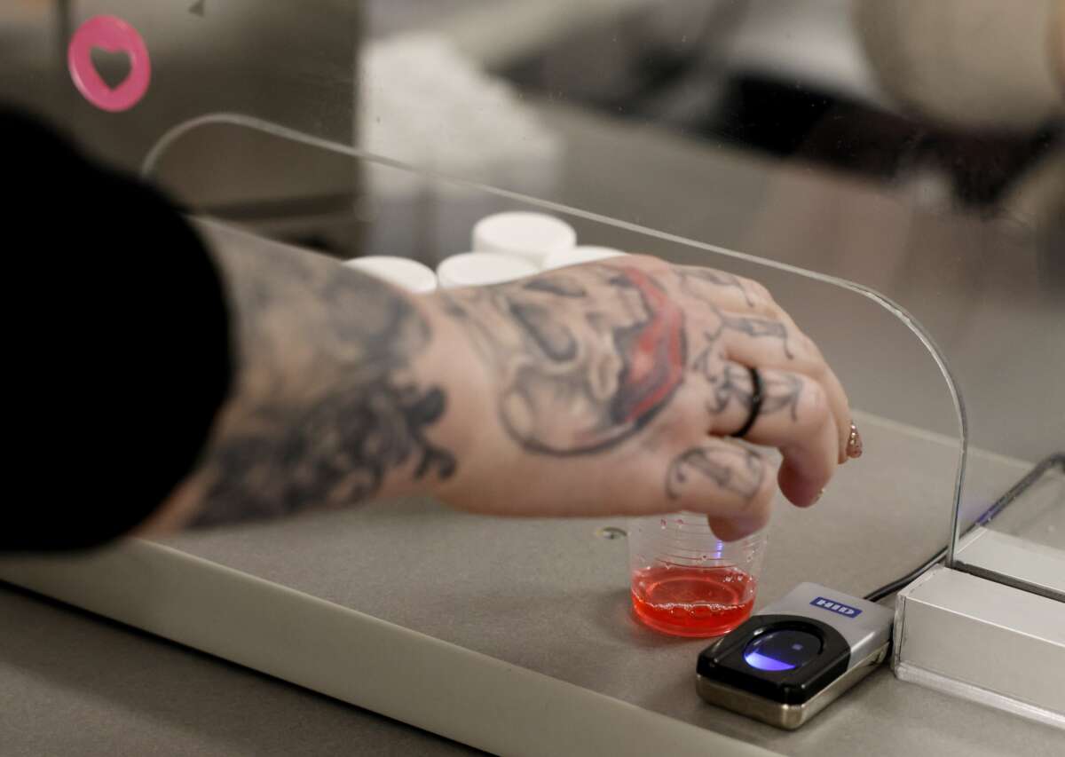 A woman reaches for a dose of methadone at the Behavioral Health Network opioid treatment clinic, in Orange, Massachusetts.