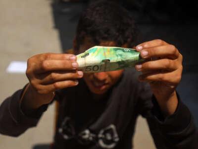 Palestinians rehabilitate and restore damaged and worn-out banknotes due to the halt in currency transfers from Israeli banks to Palestinian banks in Gaza City, on June 17, 2025.