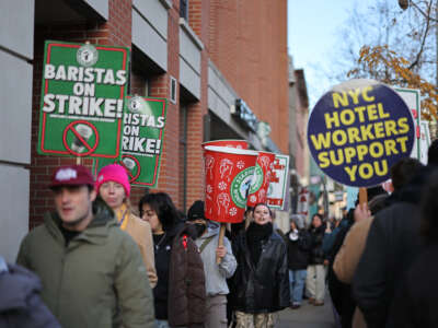 Striking Starbucks workers walk the picket line in New York on December 1, 2025.