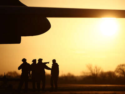 USAF military personnel work beneath a US Air Force (USAF) B-1 Lancer bomber jet at RAF Fairford in south-west England on March 14, 2026.