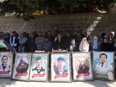 Protesters hold placards outside the Red Cross offices in Gaza City, on March 31, 2026, during a rally against a bill approved by Israel's parliament that would allow the execution of Palestinians.