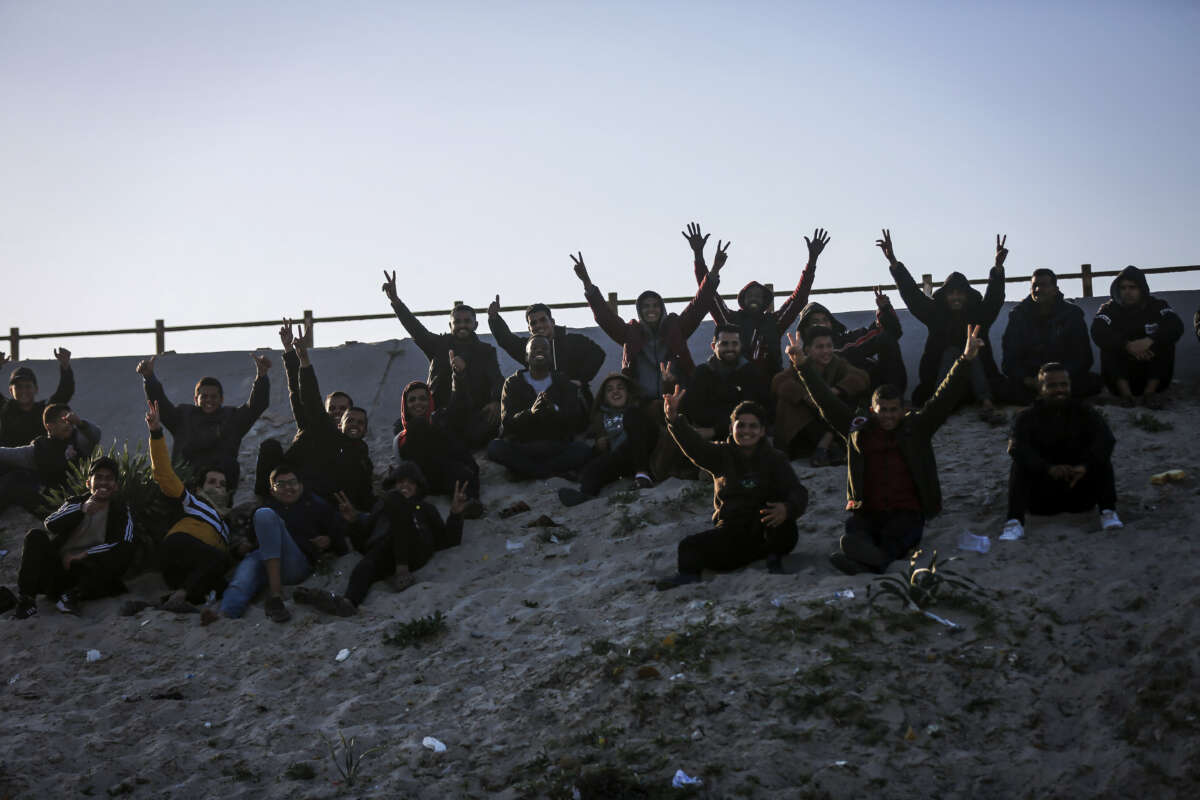Spectators react as Palestinian players play football barefoot on a sandy field beneath Wadi Gaza Bridge, south of Gaza City, on March 30, 2026.