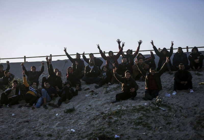 Spectators react as Palestinian players play football barefoot on a sandy field beneath Wadi Gaza Bridge, south of Gaza City, on March 30, 2026.