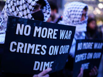 Demonstrators hold signs during a protest against U.S. military action in Iran in the Manhattan borough of New York City, on April 7, 2026.
