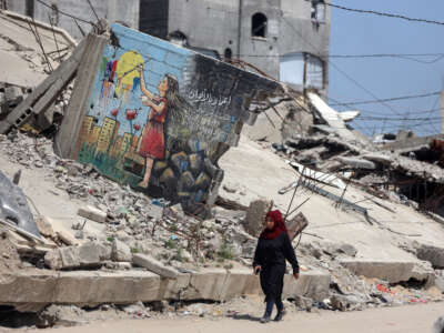 People walk past the rubble of destroyed buildings in the Jabalia camp for Palestinian refugees in the northern Gaza Strip, on April 13, 2026.