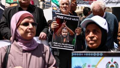Palestinian demonstrators hold pictures of prisoners held in Israeli jails, including jailed Palestinian leader Marwan Barghouti, during a rally in Ramallah, in the occupied West Bank, on April 16, 2026, to mark Prisoners' Day and to protest against Israeli parliament's approval of a new death penalty bill for Palestinians.