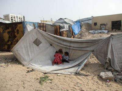 Children sit in front of a tent on April 18, 2026, in Gaza City, Gaza.