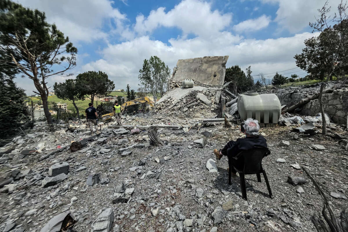 A man sits watching as Lebanese first responders search for human remains amongst the rubble the day after a house was targeted in an Israeli airstrike in the southern Lebanese city of Nabatieh, on May 1, 2026.
