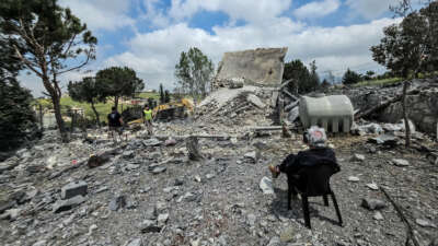 A man sits watching as Lebanese first responders search for human remains amongst the rubble the day after a house was targeted in an Israeli airstrike in the southern Lebanese city of Nabatieh, on May 1, 2026.