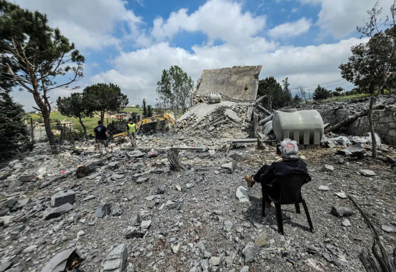 A man sits watching as Lebanese first responders search for human remains amongst the rubble the day after a house was targeted in an Israeli airstrike in the southern Lebanese city of Nabatieh, on May 1, 2026.