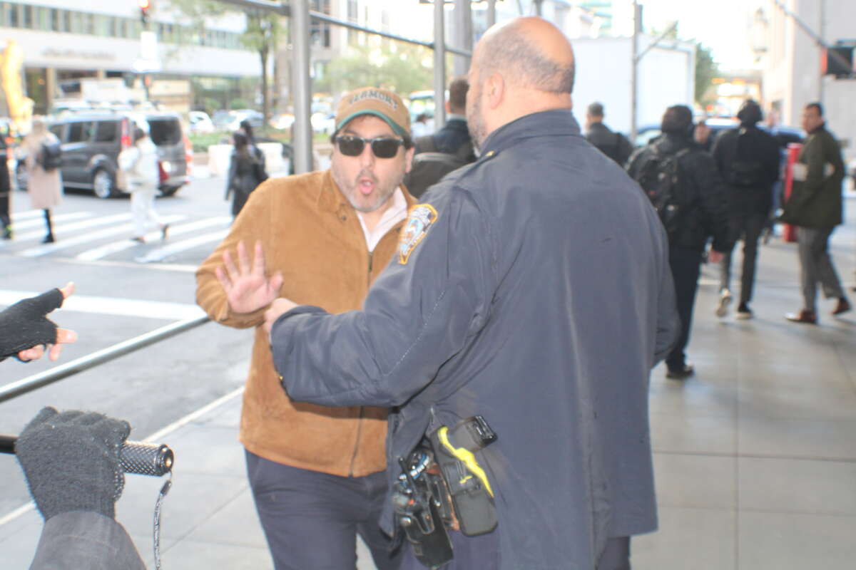 During the April 21 demonstration, a man in a tan jacket shoved two protesters and knocked into another, jeering at the crowd as the NYPD let him walk away.