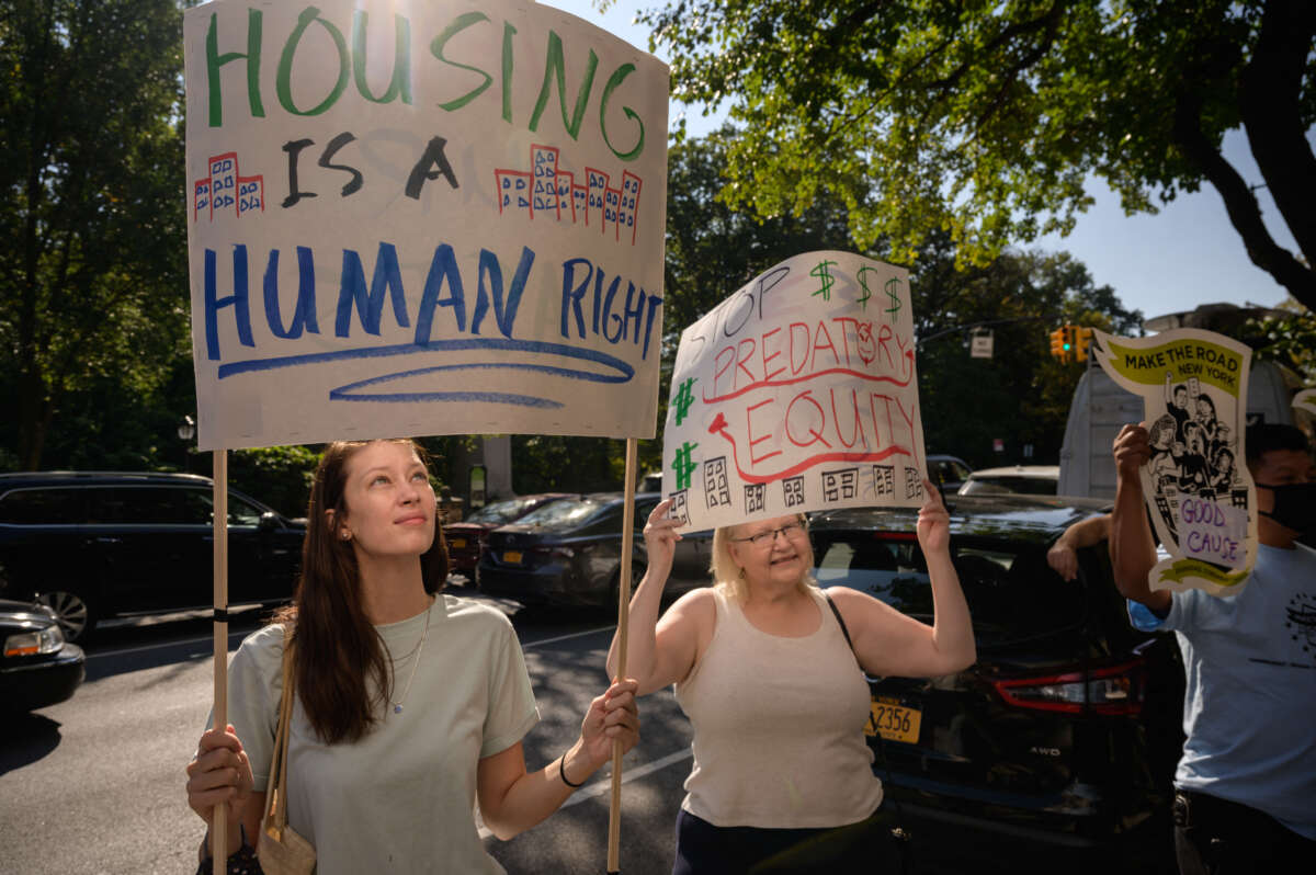 Protesters and tenants facing displacement hold placards as they attend a rally against private equity-backed firm Greenbrook Partners amid accusations of dramatically increased rents in Brooklyn, New York on October 15, 2021.