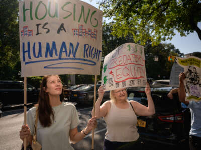 Protesters and tenants facing displacement hold placards as they attend a rally against private equity-backed firm Greenbrook Partners amid accusations of dramatically increased rents in Brooklyn, New York on October 15, 2021.