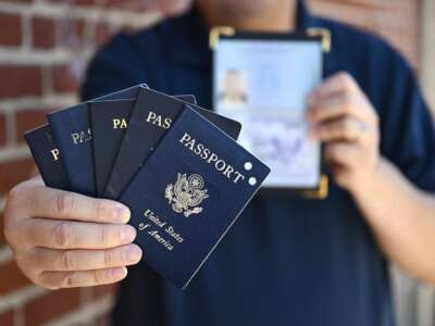 Paul Liu holds a collection of passports he's held over the years, on July 31, 2025 in Fresno, California. Some Californians are carrying their US passports to avoid ICE profiling and reduce fear of deportation.