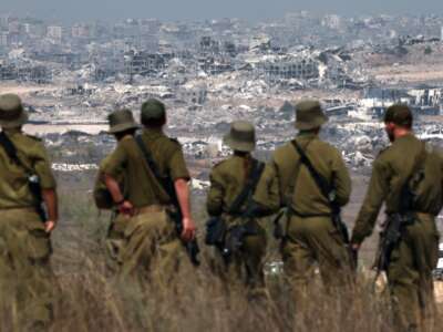 Israeli soldiers look at destroyed buildings in the Gaza Strip, on August 13, 2025.