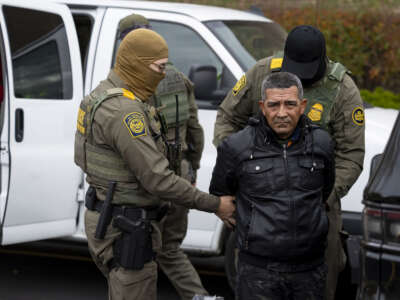 US Border Patrol agents transfer a man they took from an H-Mart parking lot into a van in a Niles, Illinois, on Oct. 31, 2025.