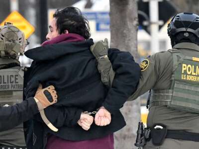 Federal agents detain a man as protestors demonstrate in Saint Paul, Minnesota, on January 8, 2026.
