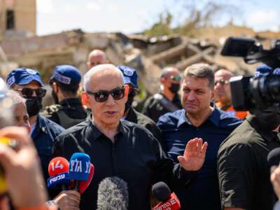 Israeli Prime Minister Benjamin Netanyahu speaks to media while visiting a site destroyed by an Iranian ballistic missile on March 22, 2026.