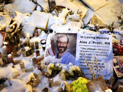 A sign with a picture of Alex Pretti is seen in the snow covered makeshift memorial, set up in the area where he was shot and killed by federal immigration agents, in Minneapolis, Minnesota, on February 1, 2026.