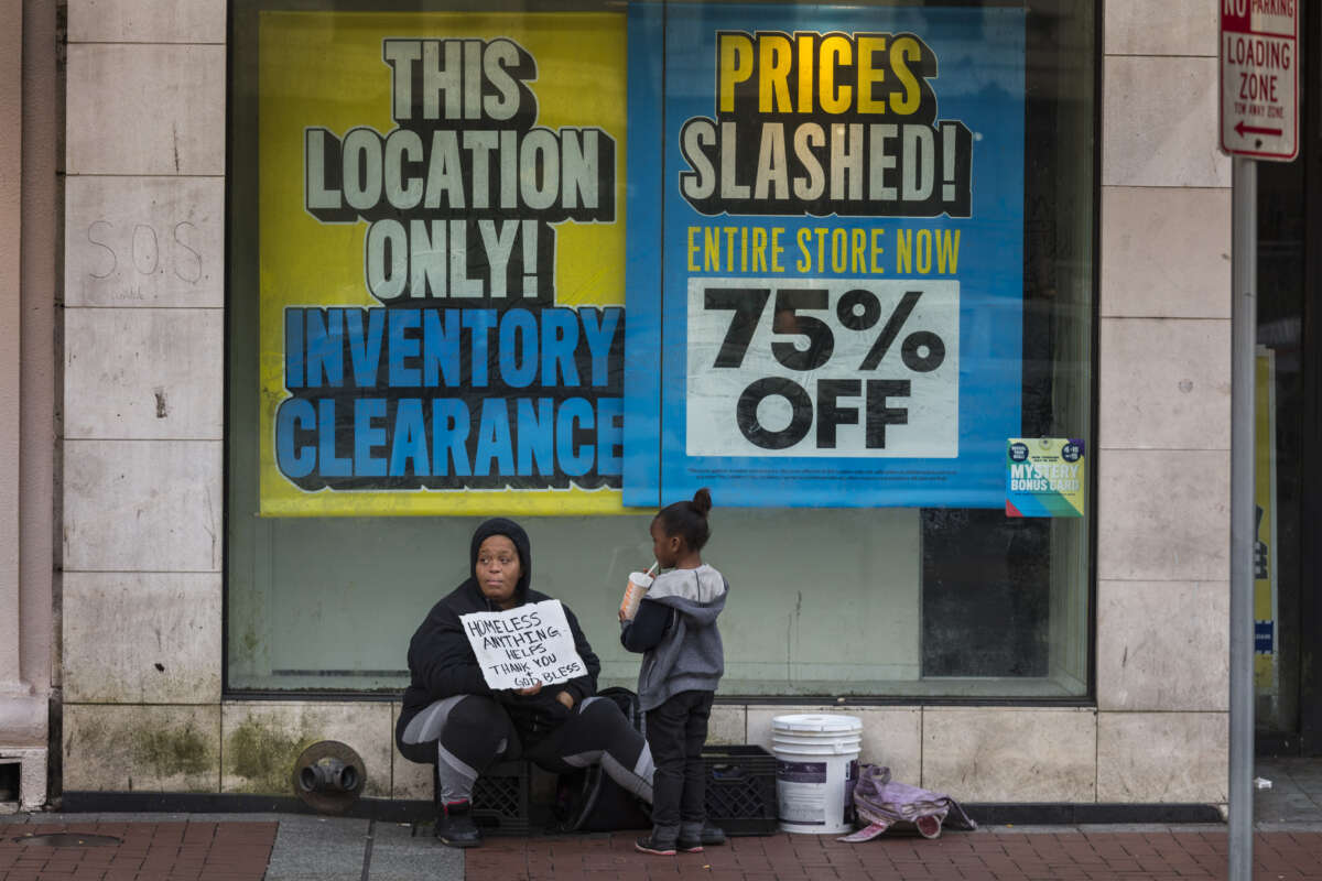 An unhoused family sits outside store on Canal street on March 11, 2020, in New Orleans, Louisiana.