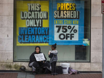 An unhoused family sits outside store on Canal street on March 11, 2020, in New Orleans, Louisiana.