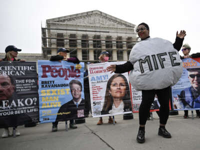 A woman dressed as a mifepristone pill dances with supporters of Planned Parenthood and pro-choice activists during a rally outside the Supreme Court on April 2, 2025, in Washington, D.C.