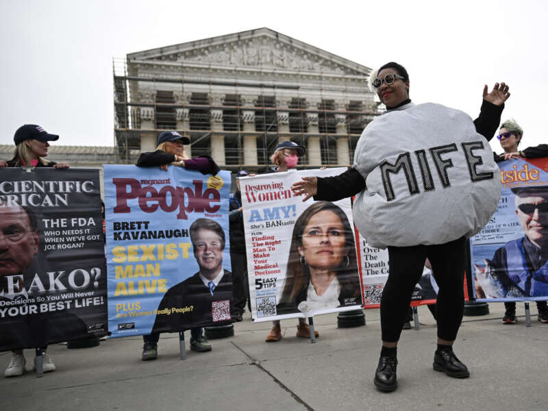 A woman dressed as a mifepristone pill dances with supporters of Planned Parenthood and pro-choice activists during a rally outside the Supreme Court on April 2, 2025, in Washington, D.C.