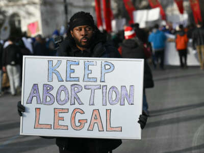 A man holds a sign reading "Keep Abortion Legal" as anti-abortion activists march in the 53rd annual March for Life rally in Washington, DC, on January 23, 2026.