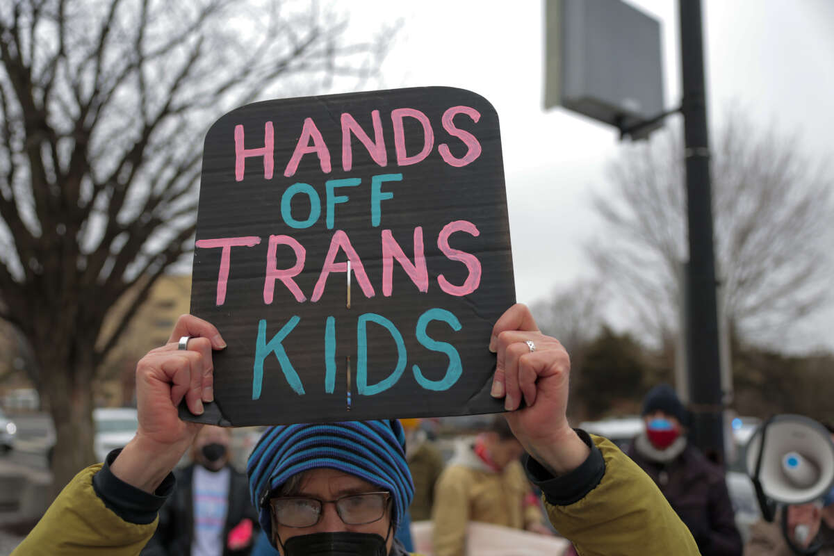 Protesters with Gender Liberation Movement and ACT UP block the entrance to the Department of Health and Human Services while protesting the Trump administration’s plan to cut federal funding to clinics providing care for transgender youth on February 17, 2026 in Washington, D.C.