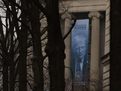 A banner of President Donald Trump is hung on the Department of Justice on February 19, 2026, in Washington, D.C. The banner reads "Make America Safe Again."