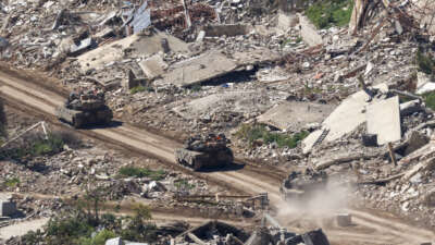 Israeli tanks drive along the road between destroyed houses in southern Lebanon near the border with Israel, on April 29, 2026.