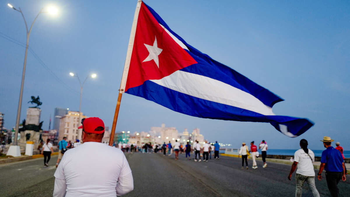 A man marches holding a Cuban national flag along Havana's waterfront to mark International Workers' Day at the AntiImperialist Platform in front of the U.S. Embassy in Havana, Cuba, on May 1, 2026.