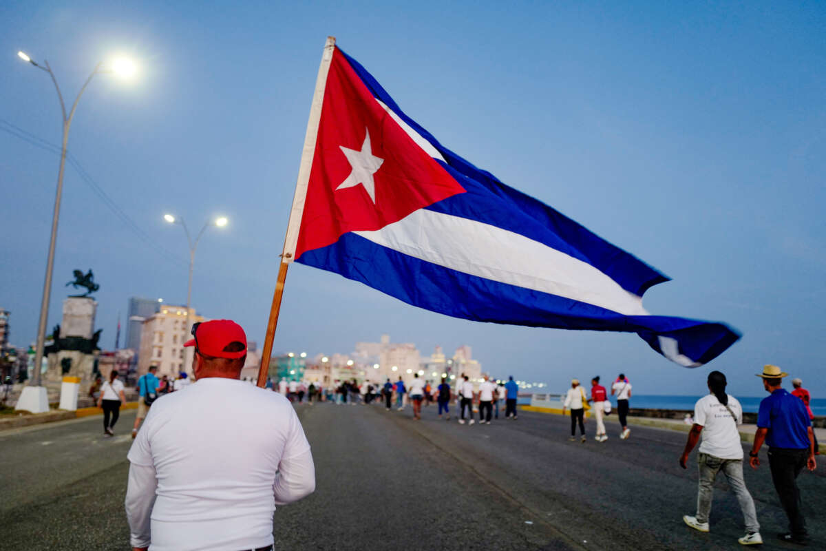 A man marches holding a Cuban national flag along Havana's waterfront to mark International Workers' Day at the AntiImperialist Platform in front of the U.S. Embassy in Havana, Cuba, on May 1, 2026.