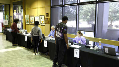 Voters check in before casting their ballots on the first day of early voting at the Louisiana State Archives on May 2, 2026, in Baton Rouge, Louisiana.